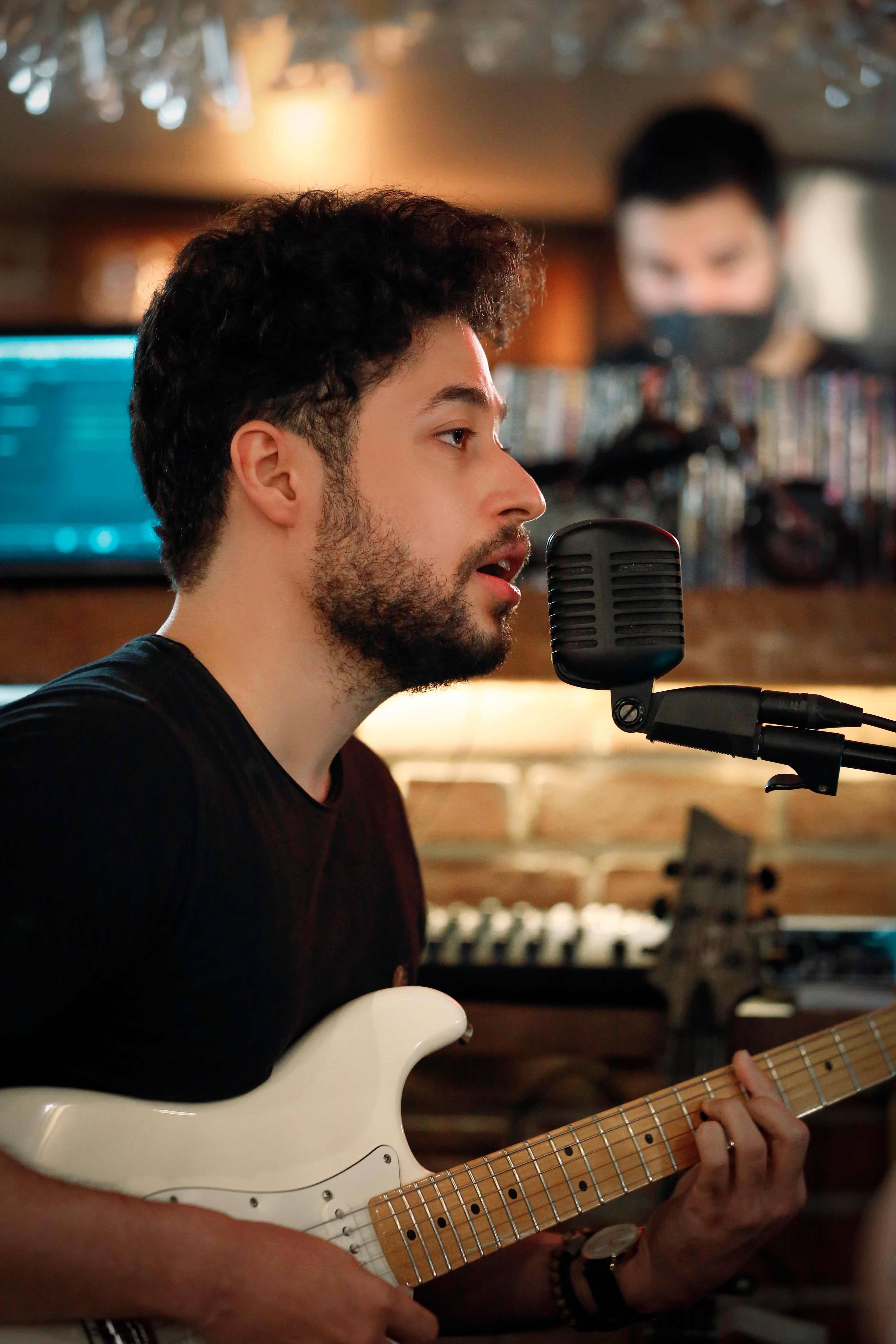Ali Diaan performing music with an acoustic guitar.